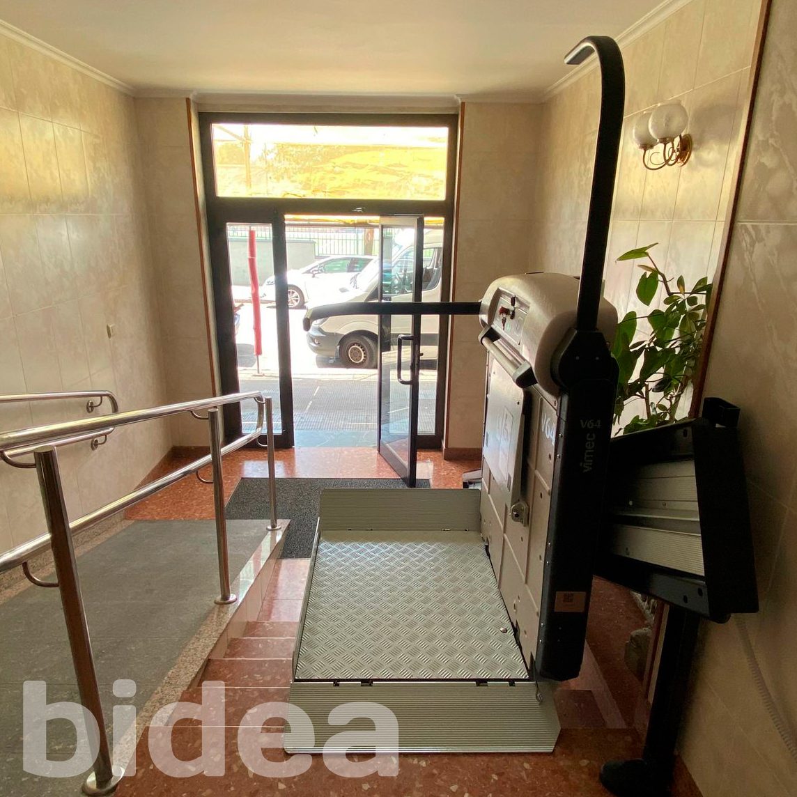 Plataforma salvaescaleras desplegada, alternativa a subir escalones en casa andando, instalada en una comunidad 