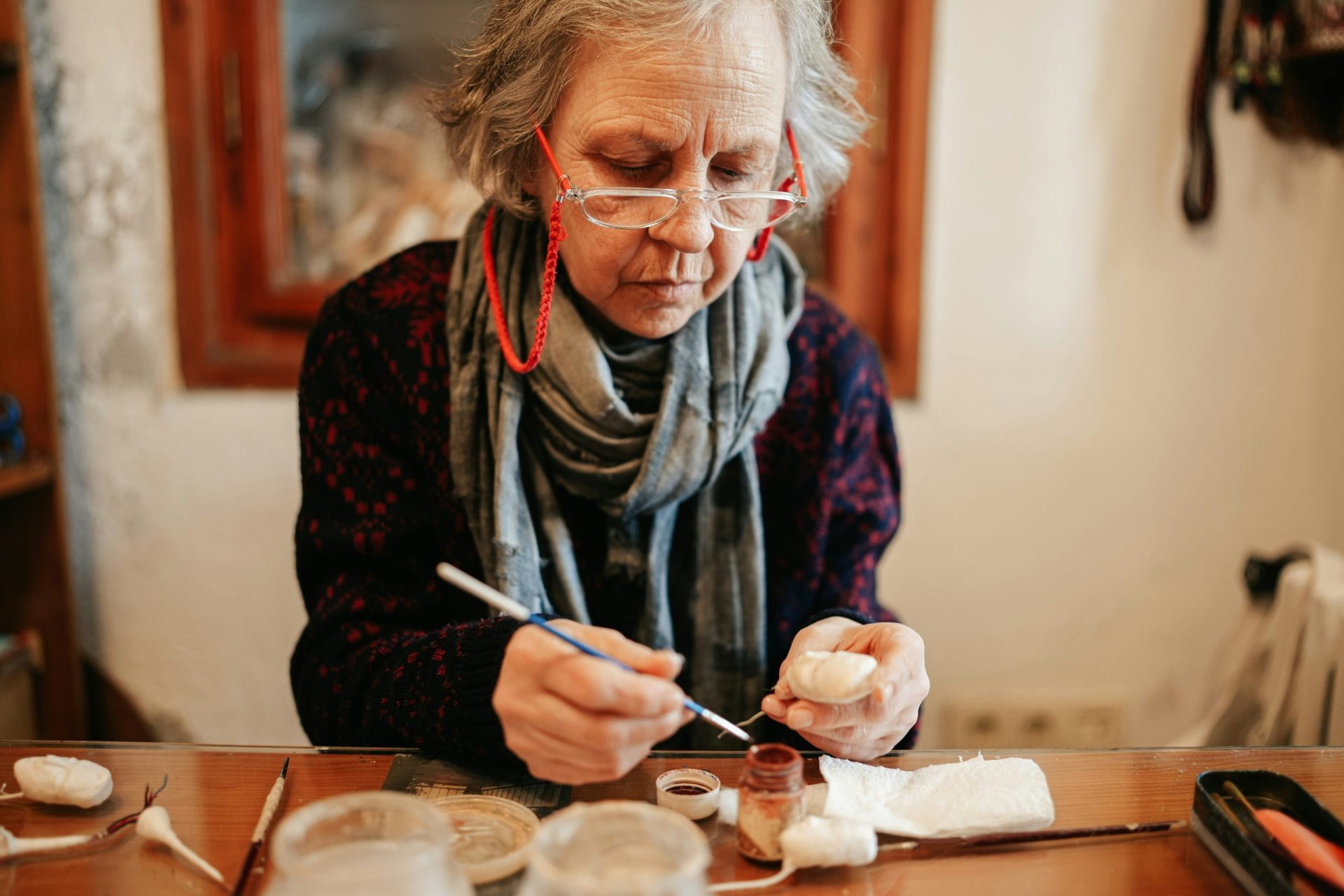 Persona mayor haciendo una manualidad, un ejemplo de los beneficios terapéuticos de las manualidades
